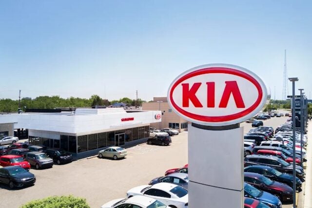 Kia sign in front of the Glassman Kia dealership lot